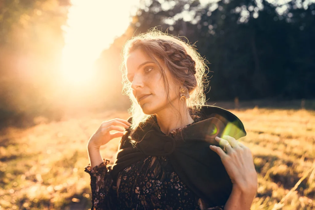 Fantasy themed photos of a woman in a cloak in the woods during golden hour.