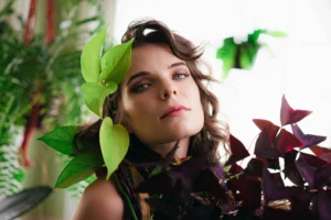 Indoor portraits of a woman surrounded by plants.