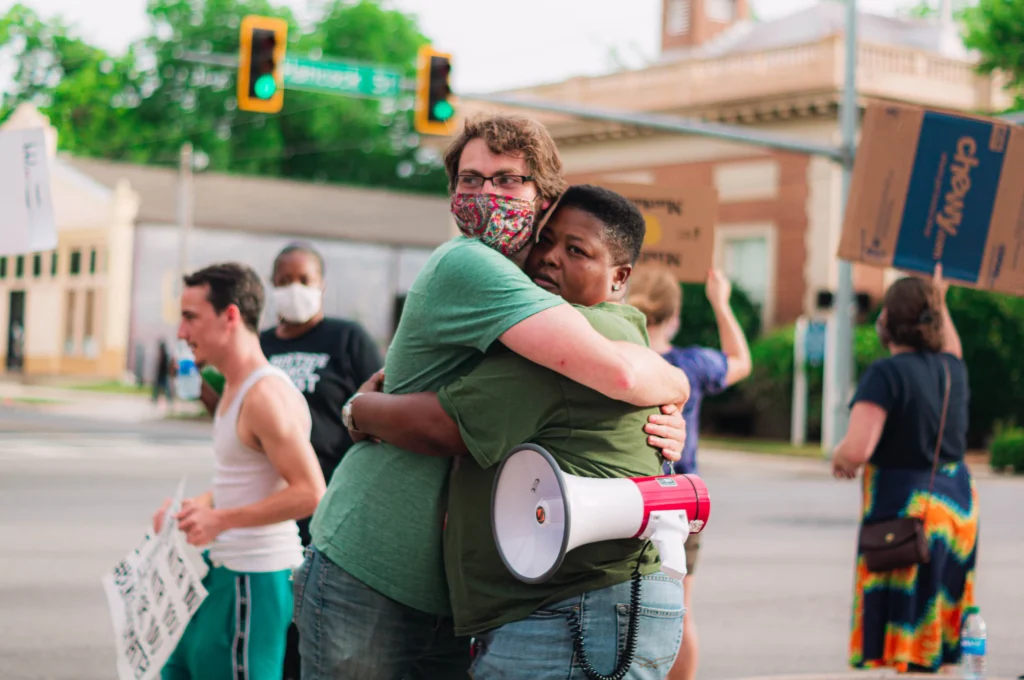 BLM protesters hugging during a peaceful protest.